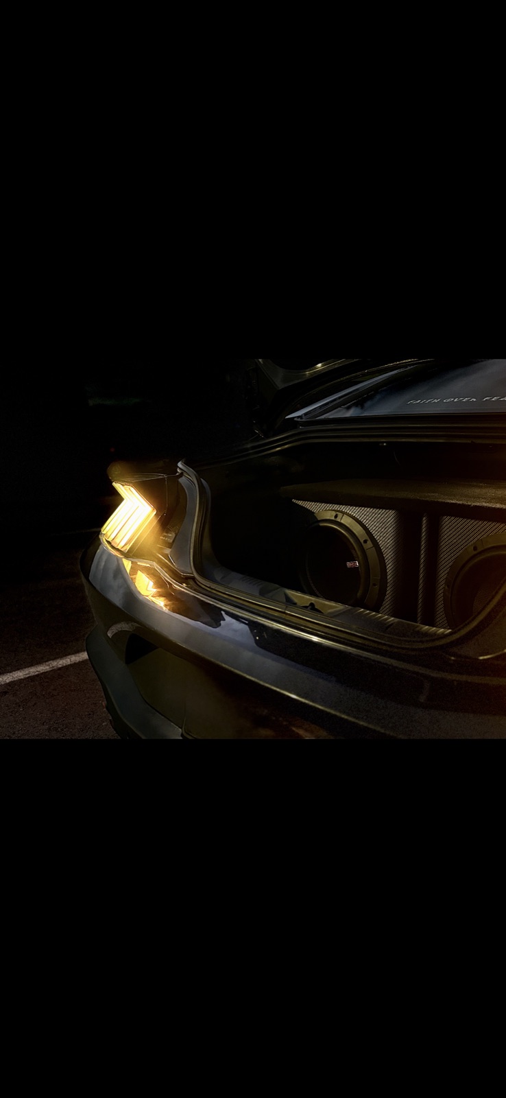 Subwoofers glowing in a car trunk at night